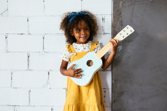 Cheerful black child with ukulele