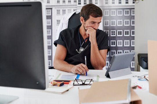 Doctor working online at his office desk