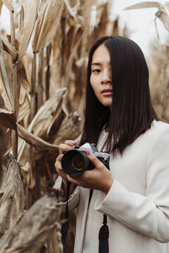 Chinese woman taking pictures outdoor with a film camera
