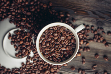 Fototapeta premium Hot drink in a saucer and sprinkled grain on a wooden table top view