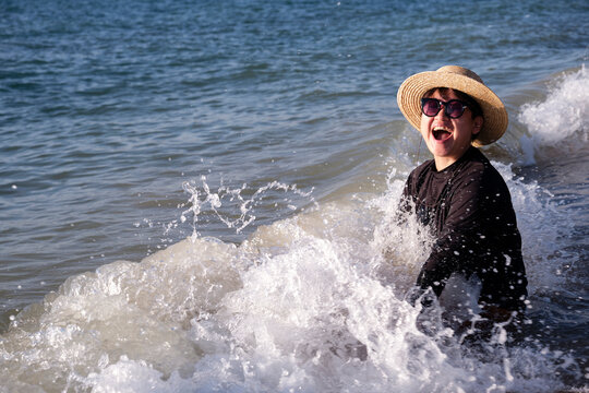 Asian woman playing on the beach during vacation