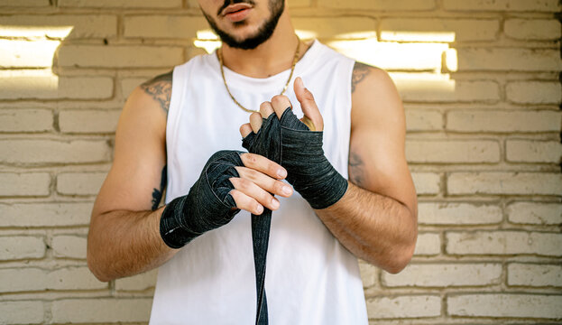 Sportsman putting on boxing wraps on hands