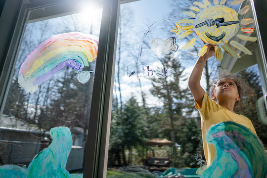 Girl paints sunshine on mural