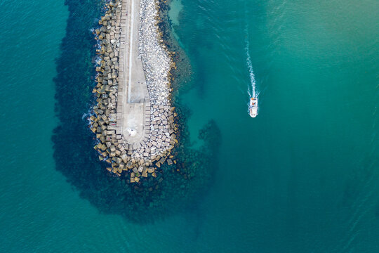 boat enters a harbour of turquoise and teal colour