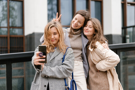 Charming women taking selfie on street