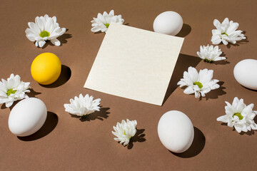 Easter 2021 composition made with white and yellow eggs and flowers on light brown background. Minimal Easter or food layout. Holiday concept.