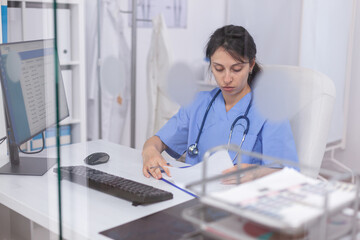 Nurse working on PC providing professional treatment services in medical clinic. Healthcare physician in hospital conducting examination for infections and disease