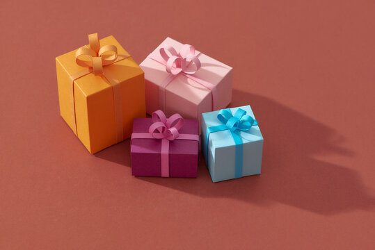Little colorful handmade gift boxes on color background