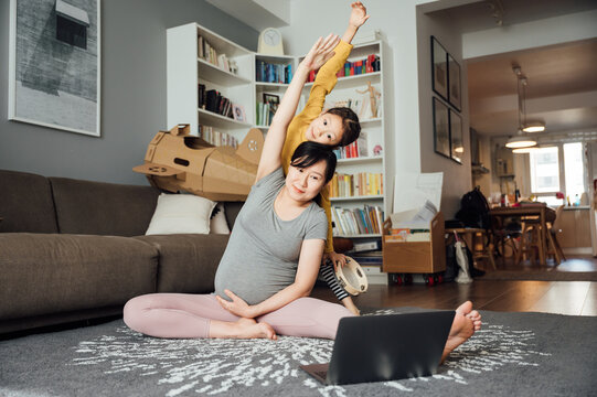 Pregnant woman doing yoga at home - Powered by Adobe