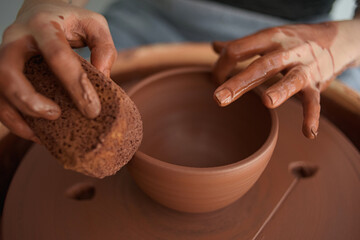 Potter's hands creating a bowl on the wheel