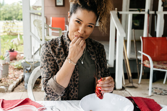 A person peeling and eating Crawfish / Crayfish