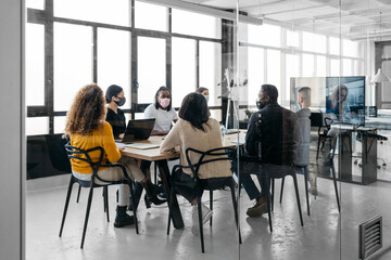 From outside view of a multiehtnic group having a business virtual meeting