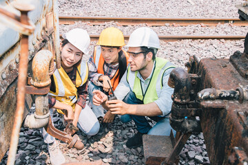 Engineers working on railway train statation and holding walkie talkie for plan and meeting. Group of professional leadership of engineering teamwork. Warehouse and successful concept. 