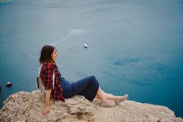 woman traveling with backpack tourist on seashore in summer