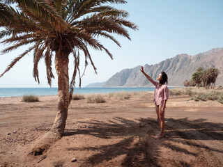 Woman under palm tree on sunny day