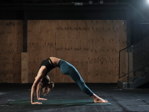 Young female exercising on the floor of a gym
