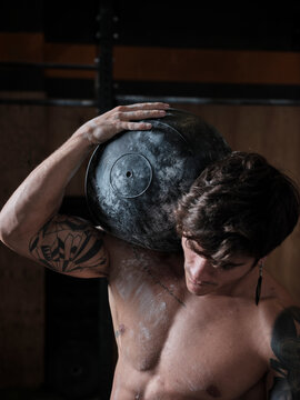 Man lifting heavy ball in the gym
