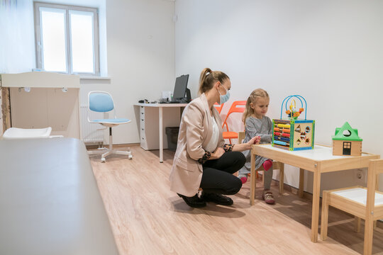 Mother And Daughter Playing In Pediatric Clinic