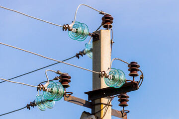 Electric pole against the blue clear sky. Three-phase power line to turn