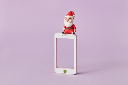 Plasticine Santa Claus sits on a smatrphone frame.