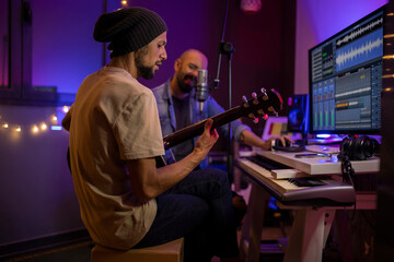 Musicians producing music in home recording studio