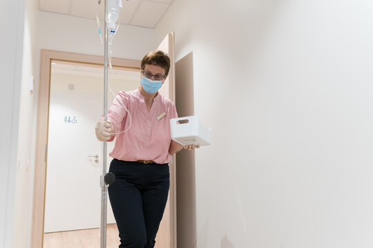 Nurse Entering Holding Drip To Patient Ward