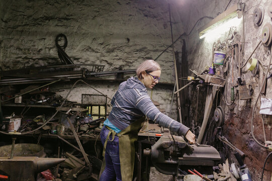 Woman Blacksmith Works In Her Workshop