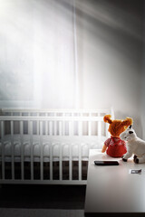 Children's gloomy room with an empty cradle and toys on the dresser. Copy space. Vertical. Concept...