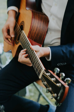 close up of man playing the guitar
