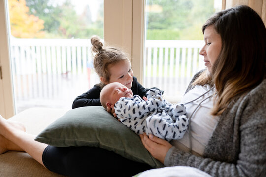 Toddler big sister touches baby brother