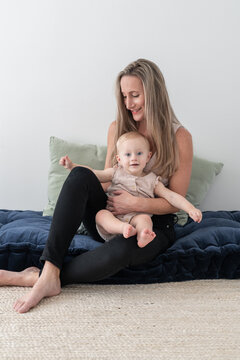 Mom sitting with baby on pillow