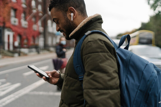 Man Crossing the Street Using a Phone