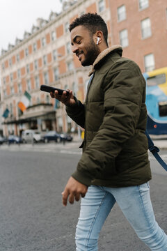 Man Crossing the Street Using a Phone