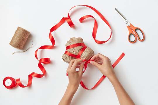 Female hands are making handmade paper gift-wrapped.