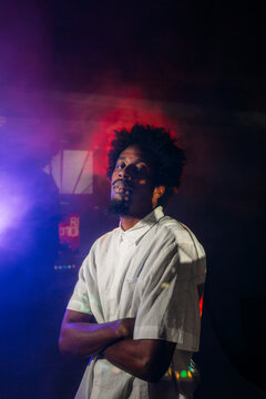 Stylish man in neon lights in dark studio
