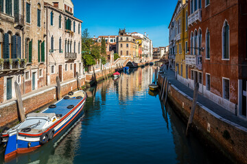 Fototapeta na wymiar Water channels of Venice city. Facades of residential buildings overlooking the small canal in Venice, Italy.