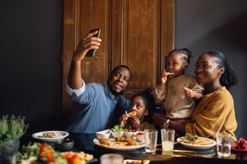 A Dad Taking a Selfie Photo of His Family in a Restaurant