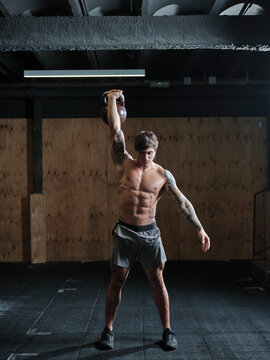 Fit man lifting weight in gym