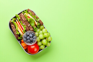 Healthy school lunch box with sandwich and fresh vegetables