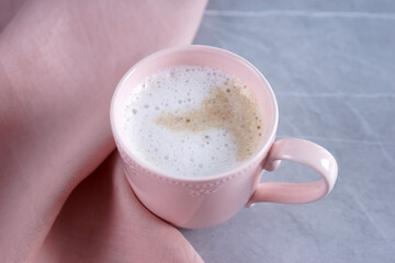 Pink mug with coffee on marble gray table
