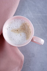 Pink mug with coffee on marble gray table