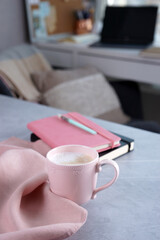 Pink mug with coffee on grey desk