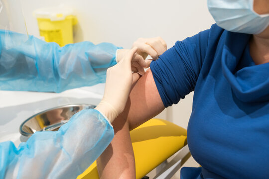 Nurse Applying Plaster To Patient
