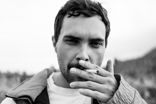 Guy Smoking Cigarette Looking Into The Camera