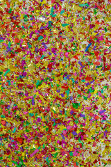 Fototapeta na wymiar colorful, glossy glitter and confetti spread on white background for festive, greeting atmosphere. pattern design artwork for banner or decorations