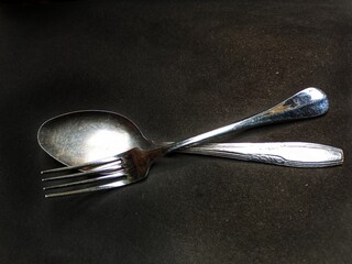 spoon and fork on black background