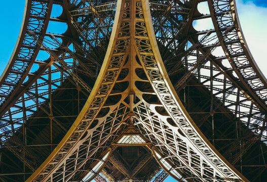 Inside the Eiffel Tower in Paris, France. View to the inside of Eiffel Tower. Big symetrical building. Close up shot in the morning. Blue sky with a sunny weather