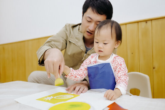 Dad accompanies his daughter to do hand painting works