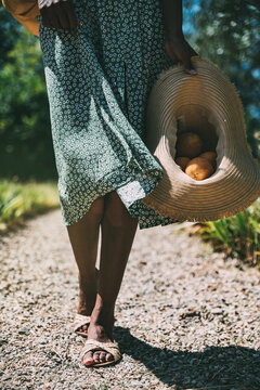 Stylish woman with fresh fruits walking in garden