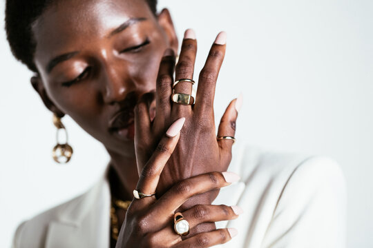 Ethnic woman in stylish rings on fingers in studio